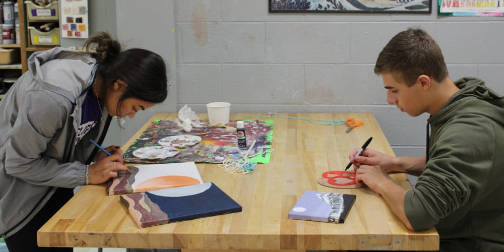 OHS students working on artwork on table