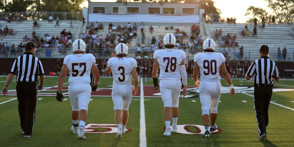 OHS Football players and referees walking toward bleachers