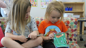 Two students reading a book together